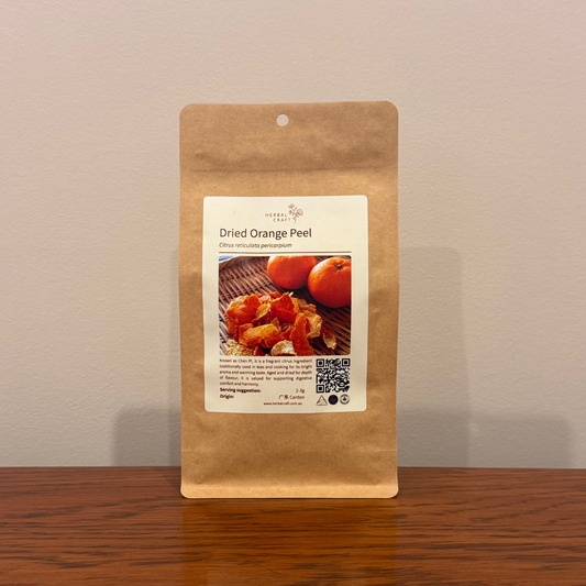 Kraft paper package of dried orange peel with a label on a wooden surface.