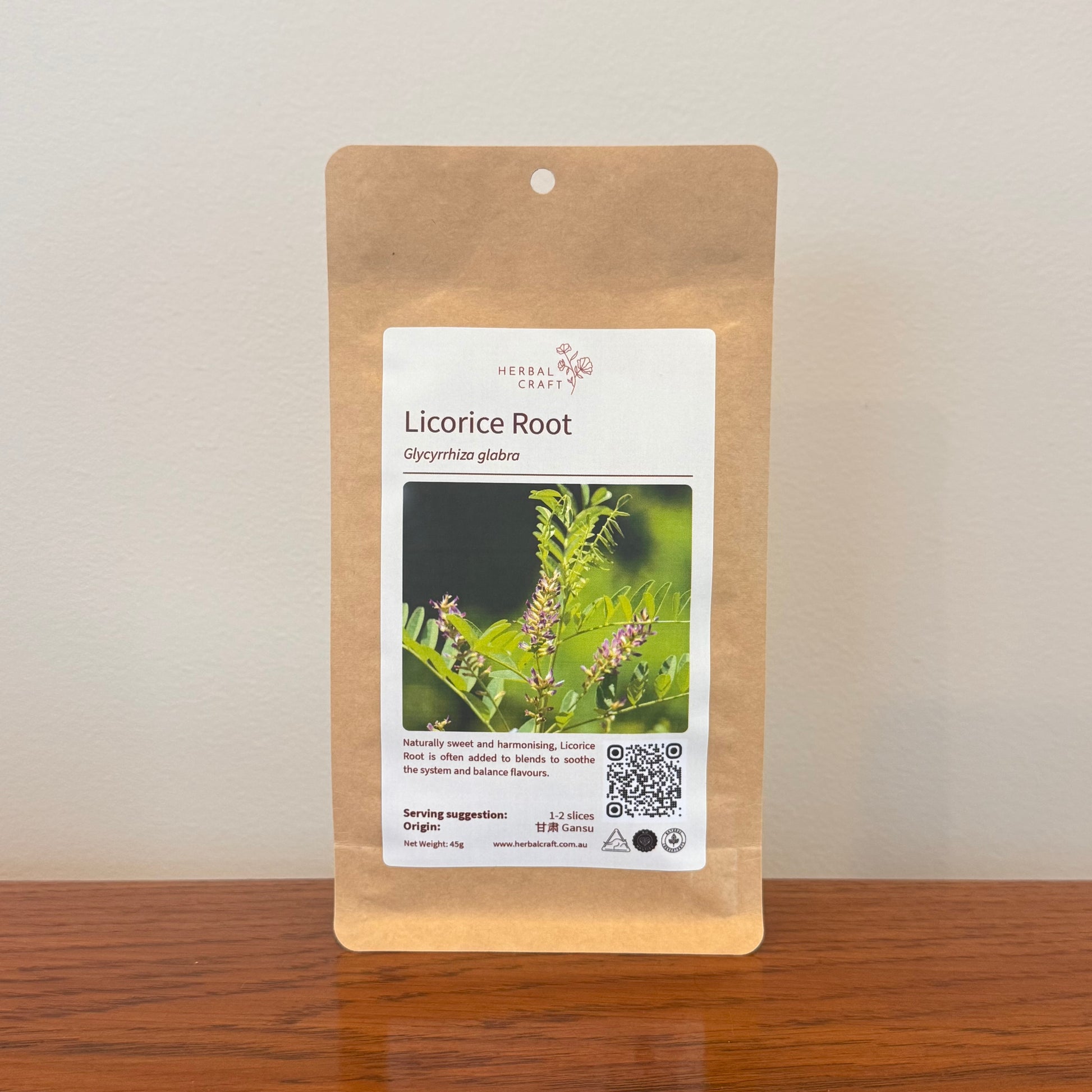 Kraft paper packaging of licorice root with a label on a wooden surface.