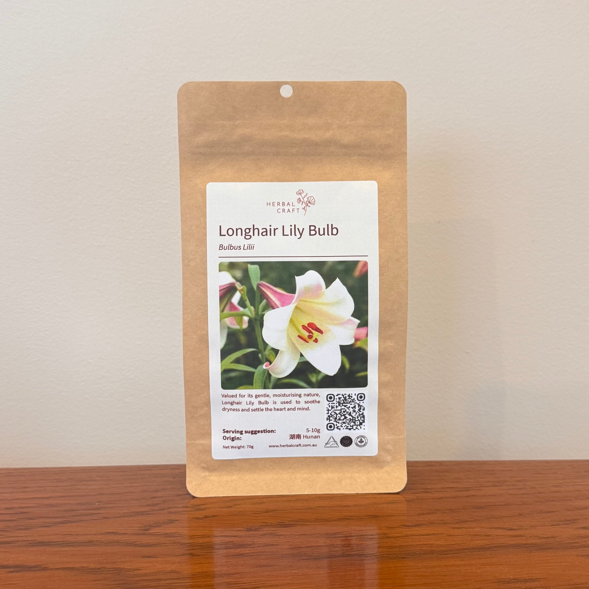 Kraft paper packaging with a label for Longhair Lily Bulb on a wooden surface.